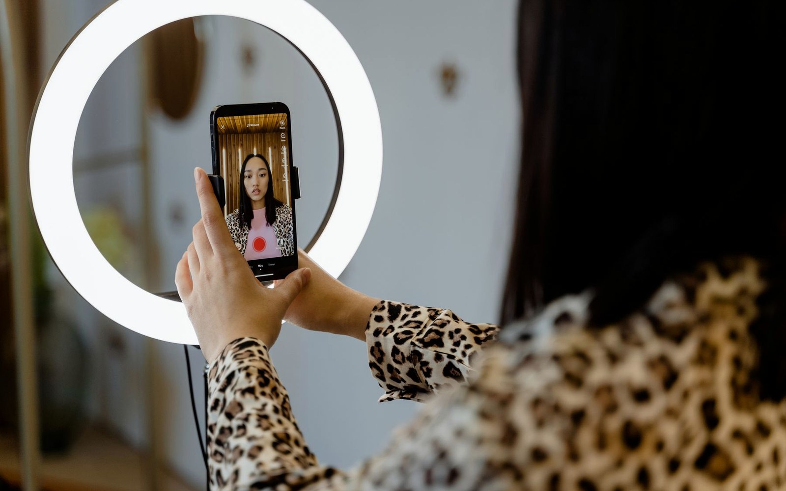 Creator recording social video content with a smartphone and ring light
